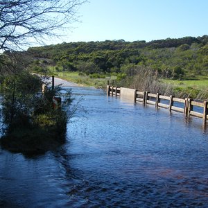 Die ou laagwaterbruggie (bo) oor die Uilkraalrivier onderkant die Kraaiboschdam se uitloop op die Gansbaai / Bredasdorppad, via Baardskeerdersbos en Elim, wat gedurende die groot reÃ«ns in Oktober/Desember 2013 vir die laaste keer oorstroom is, is onlangs met â€˜n â€œBoere Brugpartytjieâ€ gegroet en die nuwe brug (onder) is verwelkom. Die nuwe brug is reeds vir verkeer oopgestel en die pad kan gedurende die Feestyd tot by die Napier-afdraai gebruik word.